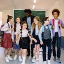 Group of schoolchildren with their teacher walking together inside a classroom